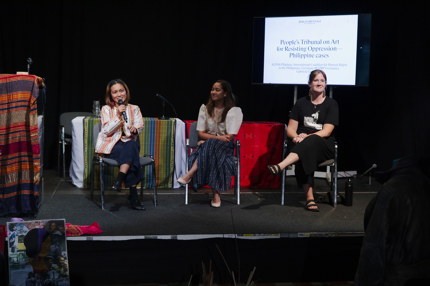 Kunst-Werke Berlin e. V., drei Sprecherinnen auf einer Bühne bei Podiumsdisskusion